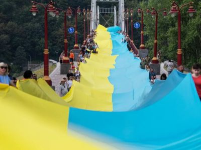 Активисты держат 430-метровый флаг Украины на пешеходном мосту через Днепр. Фото: Andrew Kravchenko / AP Активисты держат 430-метровый флаг Украины на пешеходном мосту через Днепр. Фото: Andrew Kravchenko / AP